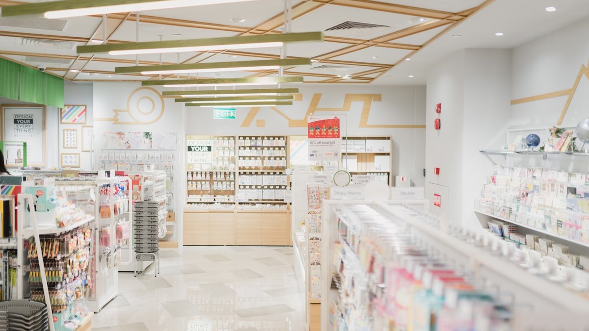 明るい文房具店の店内。グリーティングカードや事務用品が棚に並んでいる